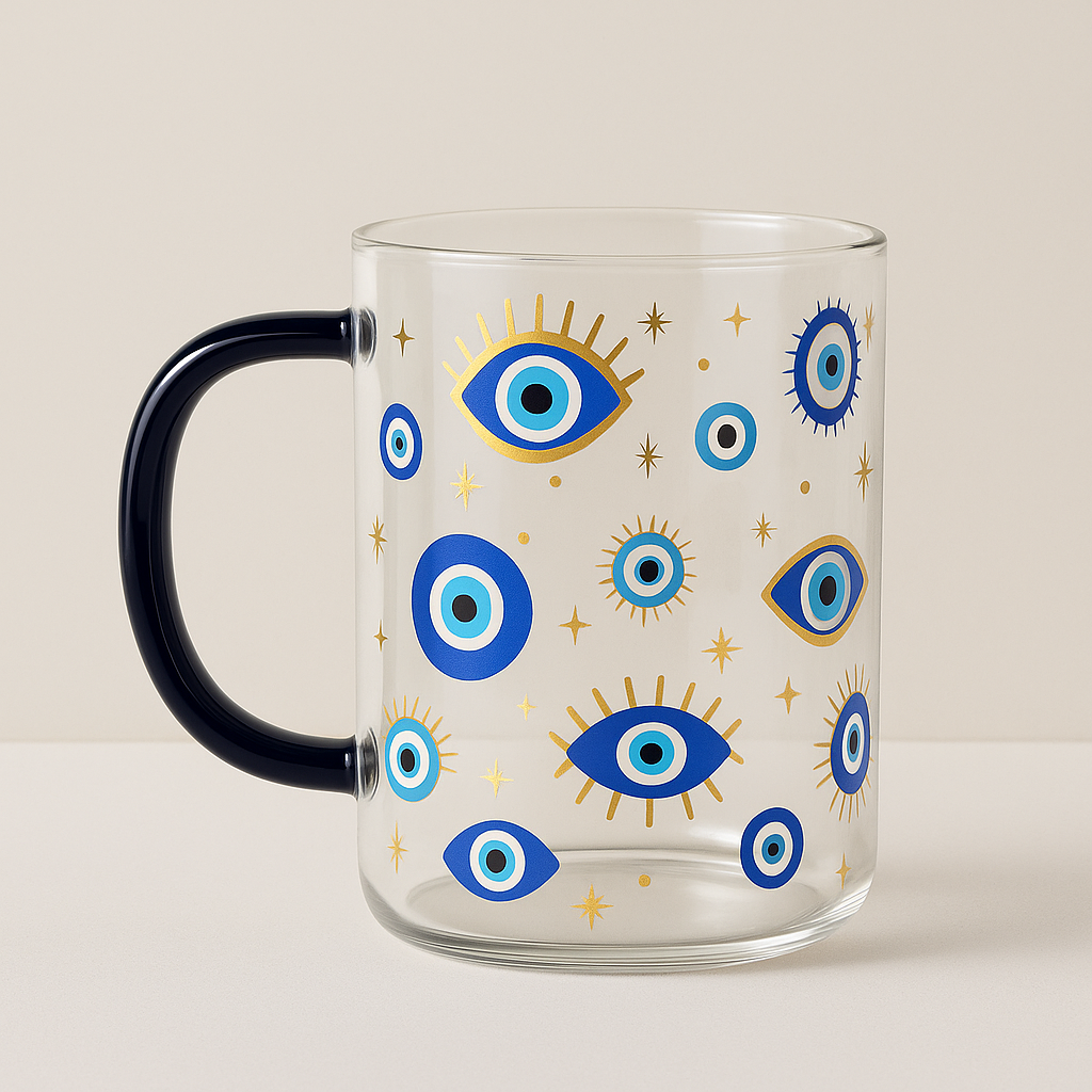 Clear glass mug with blue and gold evil eye motifs and celestial accents, navy handle.