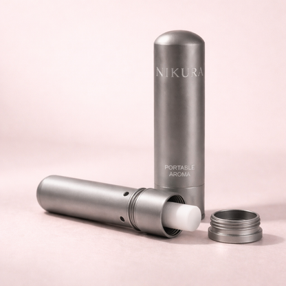 Nikura Portable Aroma aromatherapy inhaler disassembled showing the cap, body and cotton wick on a blush pink background – THE AURA CO.