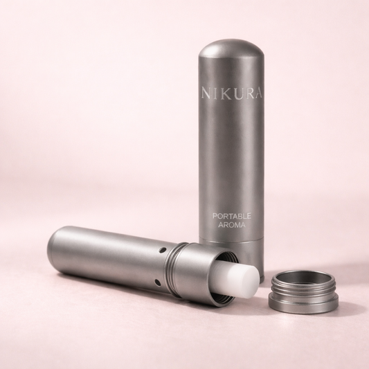 Nikura Portable Aroma aromatherapy inhaler disassembled showing the cap, body and cotton wick on a blush pink background – THE AURA CO.