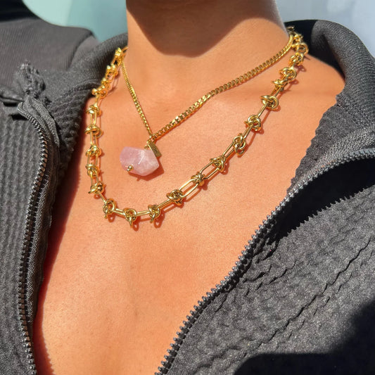 Rose quartz crystal pendant necklace worn layered with a chunky gold knot chain choker – The Love Choke by THE AURA CO.
